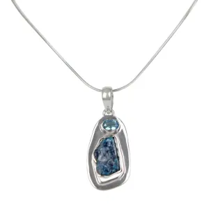 A beautiful rough Neon Apatite pendant accent with a Blue Topaz and elegantly hand set in Sterling Silver bazel.